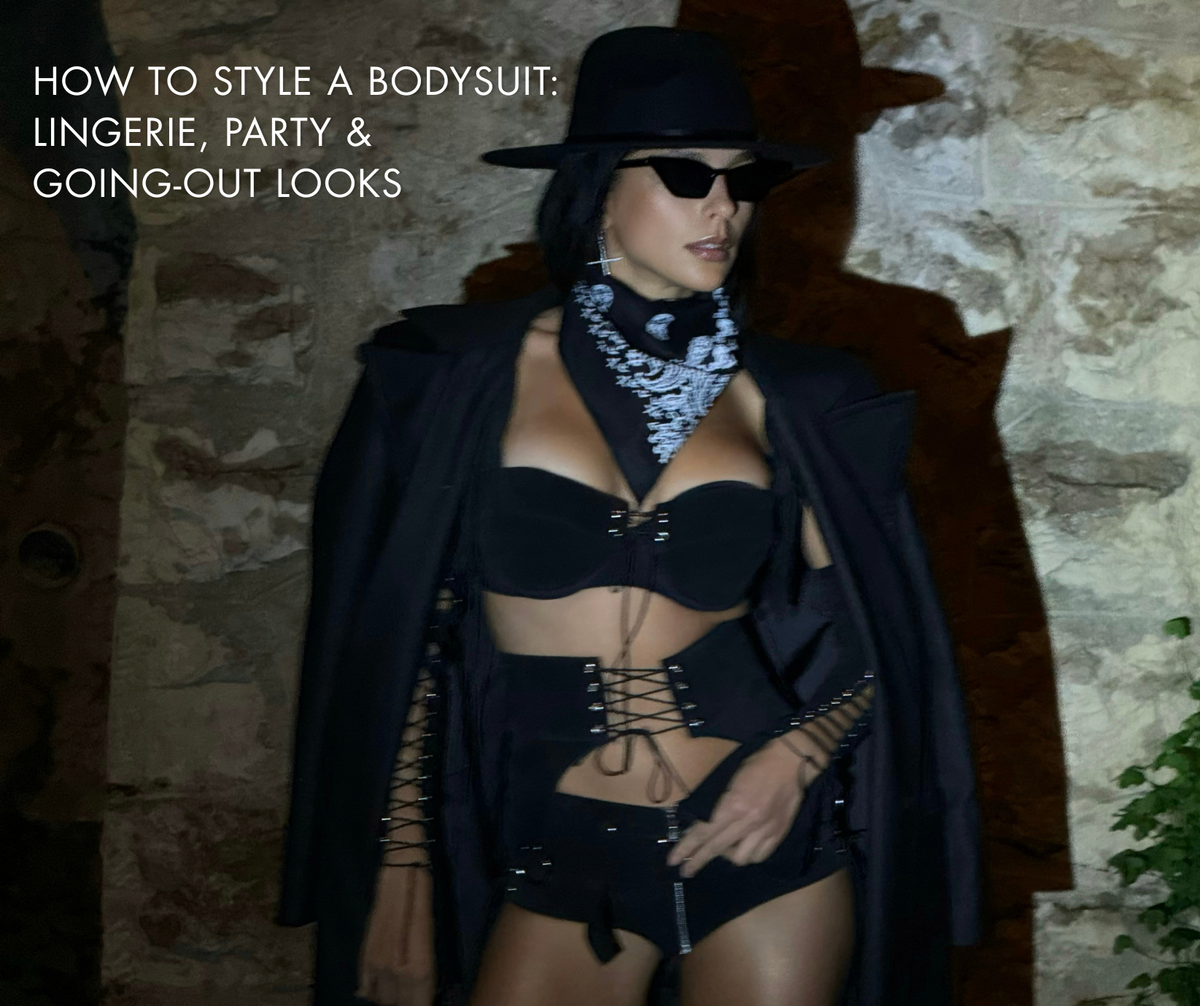 Woman in a black lingerie outfit styled for a party look with a hat, sunglasses, and blazer.